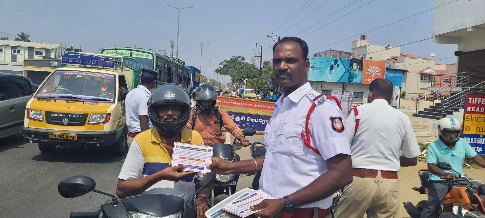 “ஹெல்மெட் ரொம்ப முக்கியம்”…. இனிப்புகள் வழங்கி நூதன விழிப்புணர்வு…. போலீசாரின் முயற்சி…!!